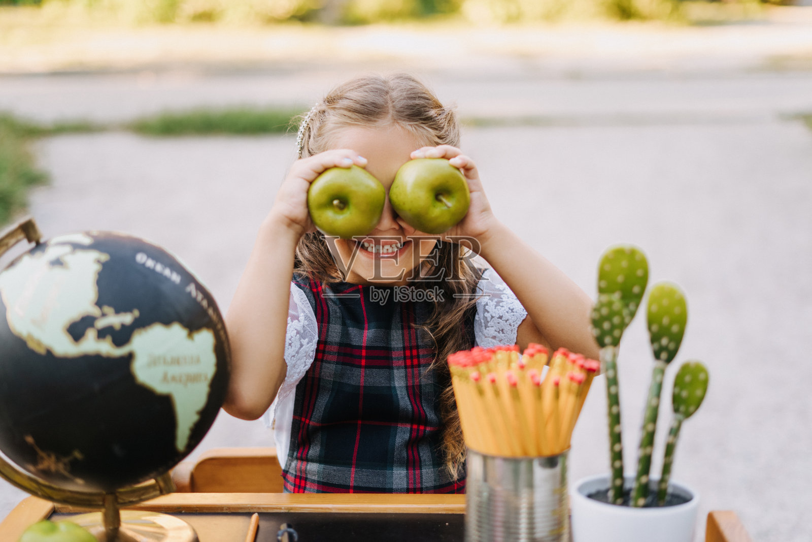 滑稽的小学生微笑，在书桌上闲逛照片摄影图片