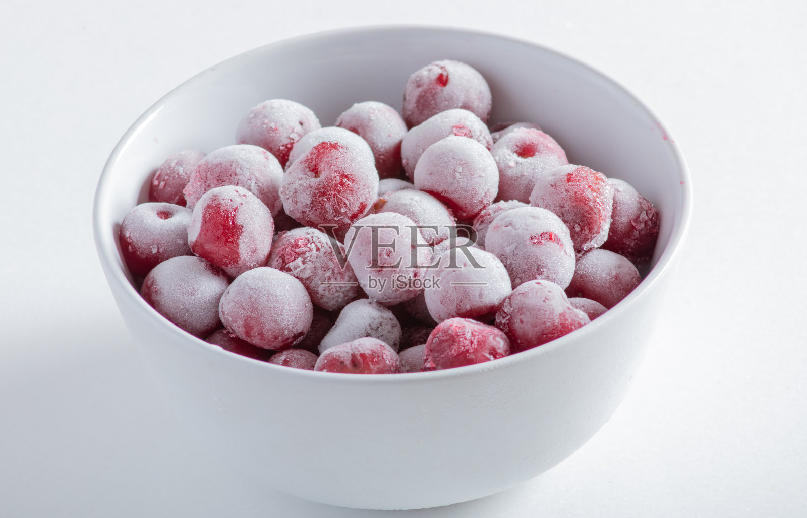 白色盘子里的冰冻浆果，背景很亮照片摄影图片