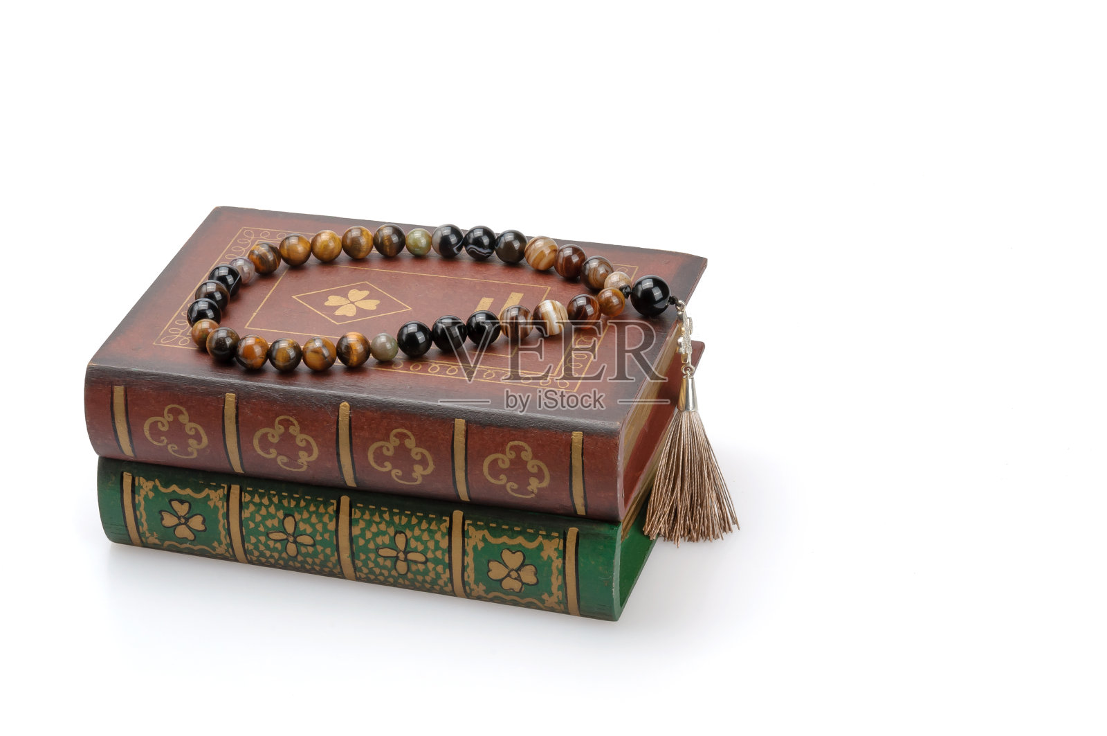 白底上有书和念珠的静物画。照片摄影图片