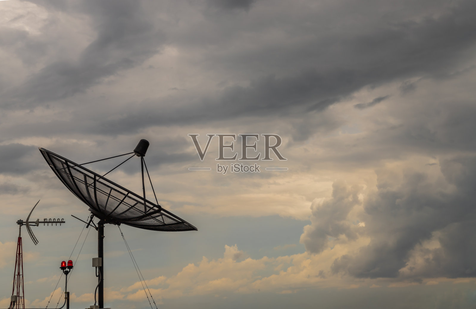 黑色卫星碟形天线接收器在蓝天背景下的通信和媒体行业。照片摄影图片