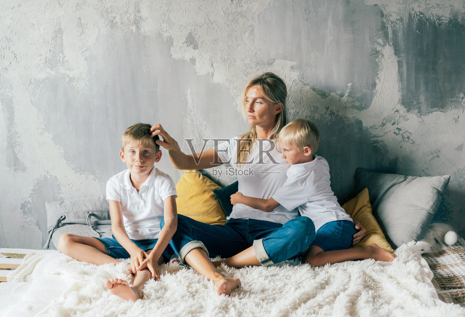 一个甜蜜的欧洲家庭，一个善良和支持的行为。母亲拥抱学龄前的孩子。照片摄影图片