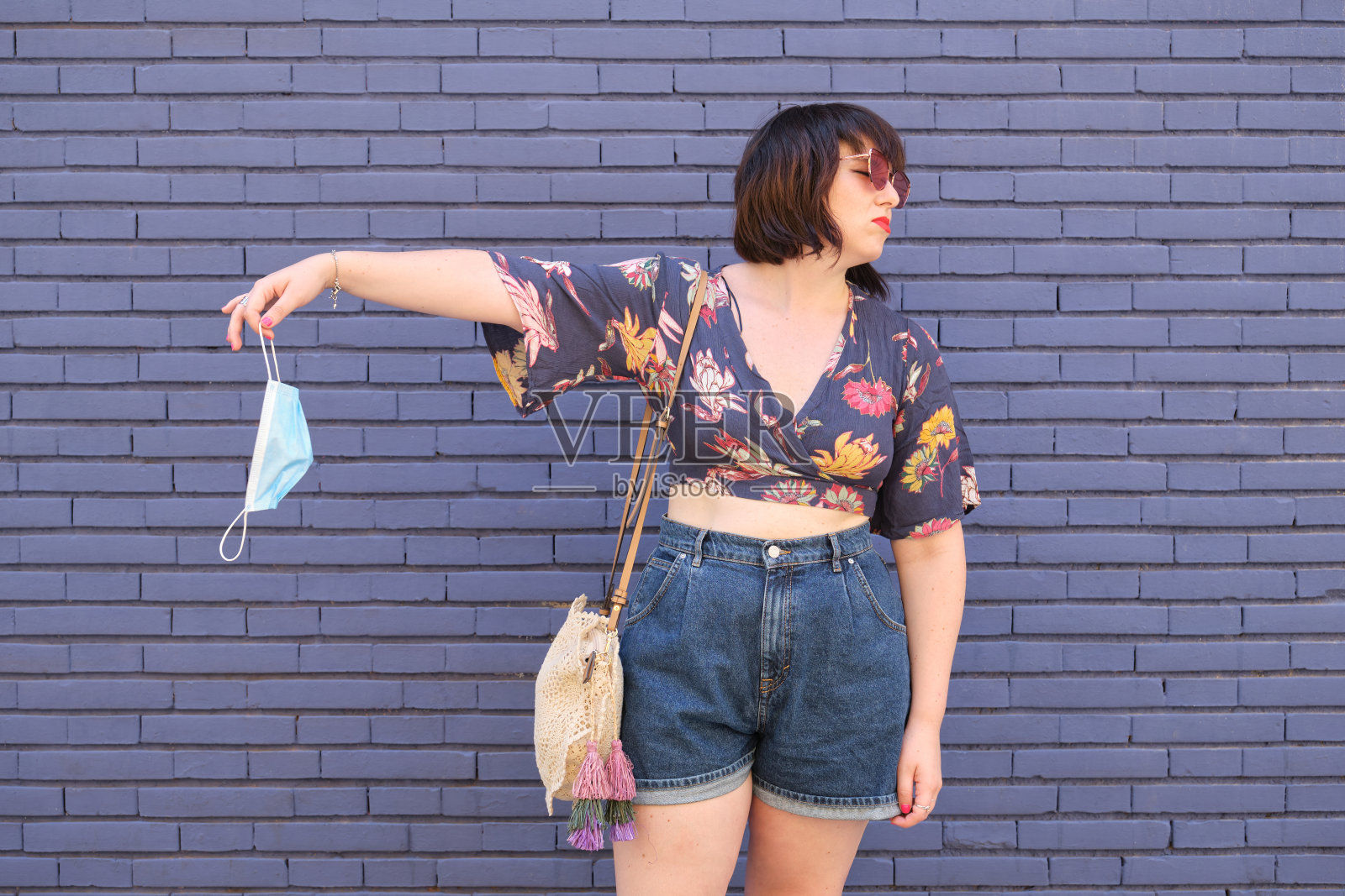 年轻的白人女子拒绝戴口罩。冠状病毒预防的概念。照片摄影图片