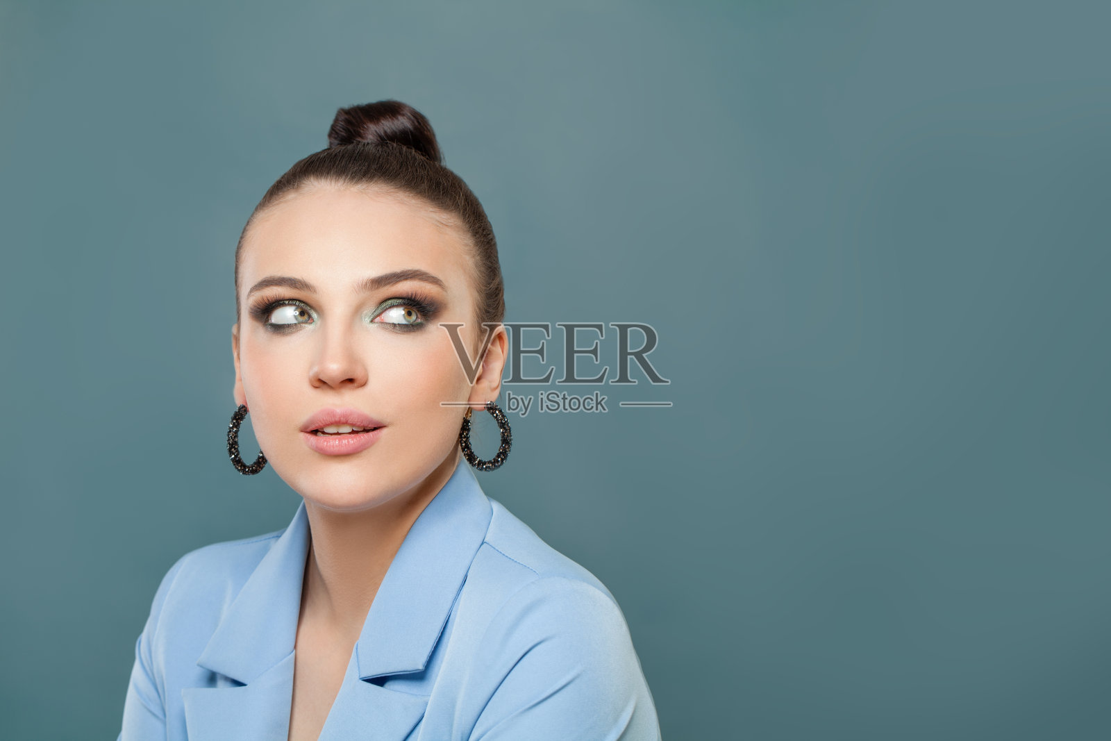 有魅力的女人看着一边在蓝色的背景照片摄影图片