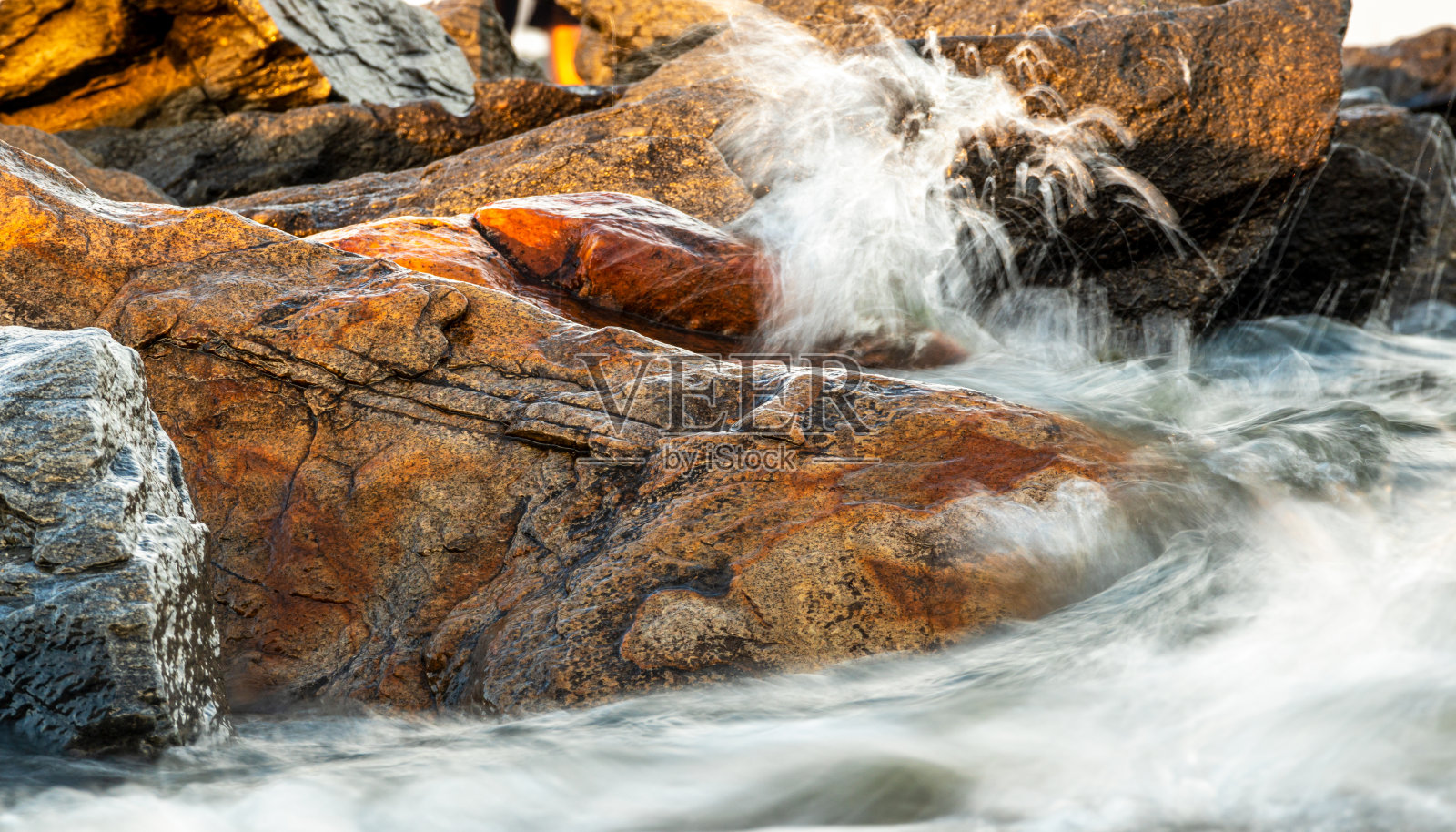 海浪围绕着石头照片摄影图片