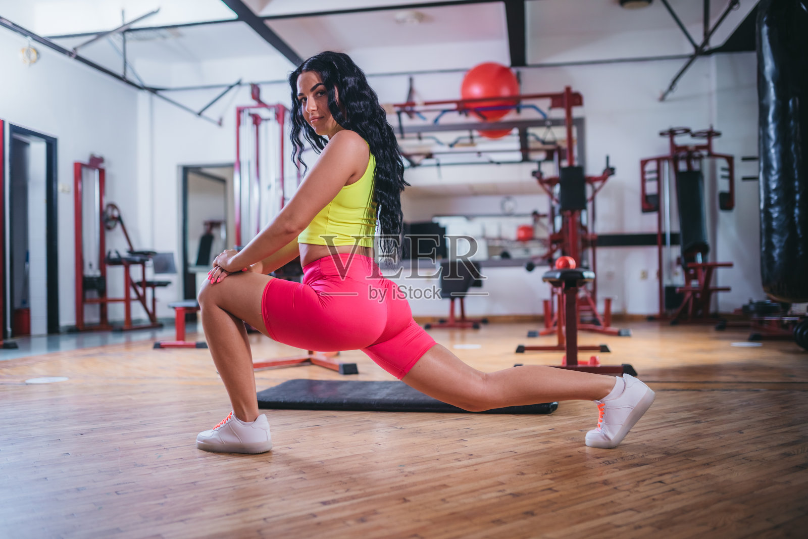 年轻漂亮的年轻女人穿着运动服在健身房做伸展运动照片摄影图片