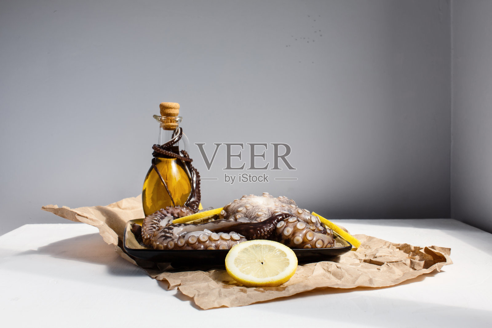 海鲜，整只生大章鱼放在盘子里，用柠檬和橄榄油准备准备照片摄影图片