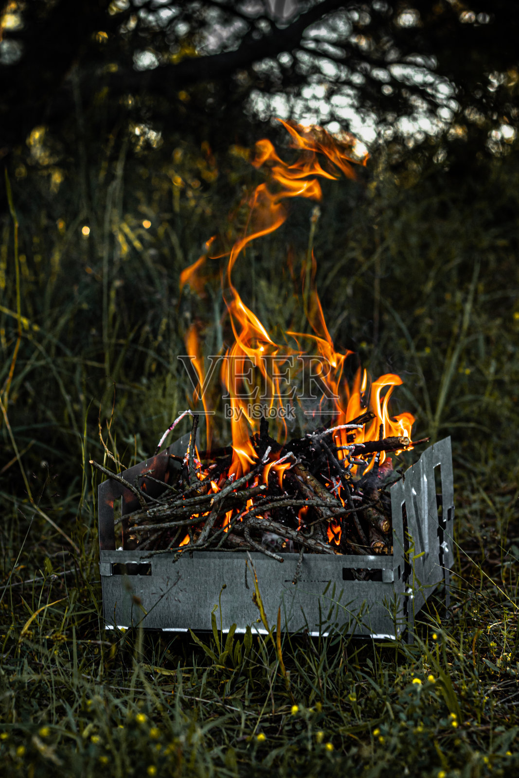 在烤架上燃烧煤炭，火焰和烟。照片摄影图片