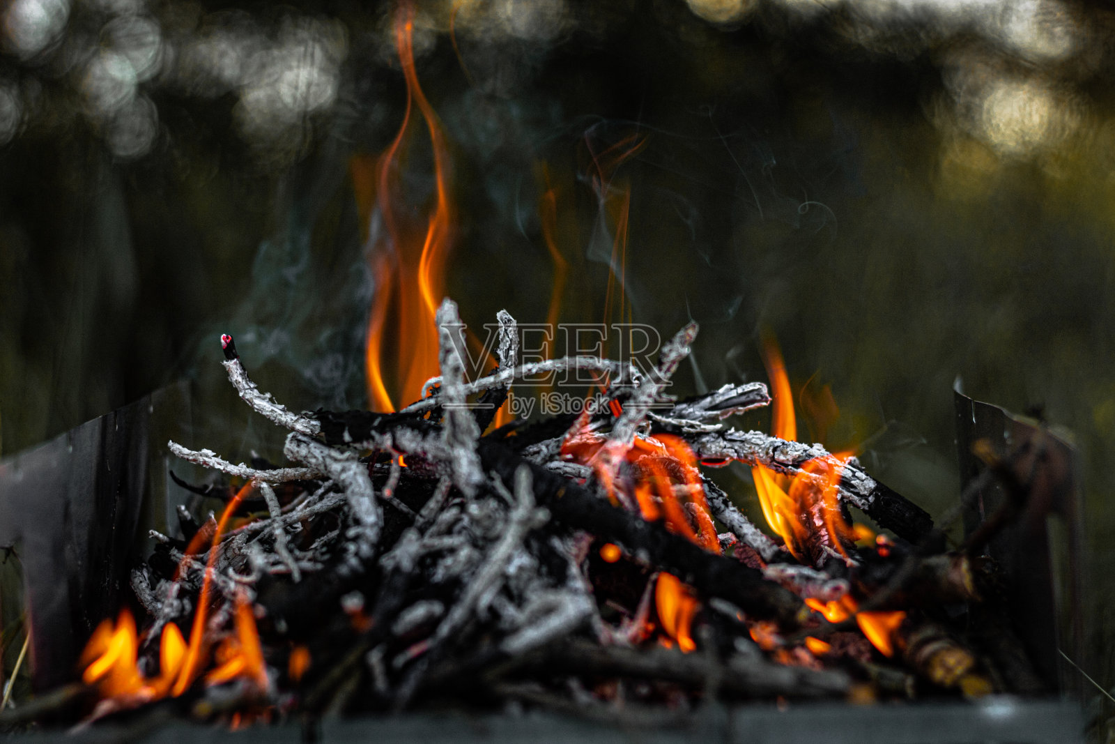 在烤架上燃烧煤炭，火焰和烟。照片摄影图片