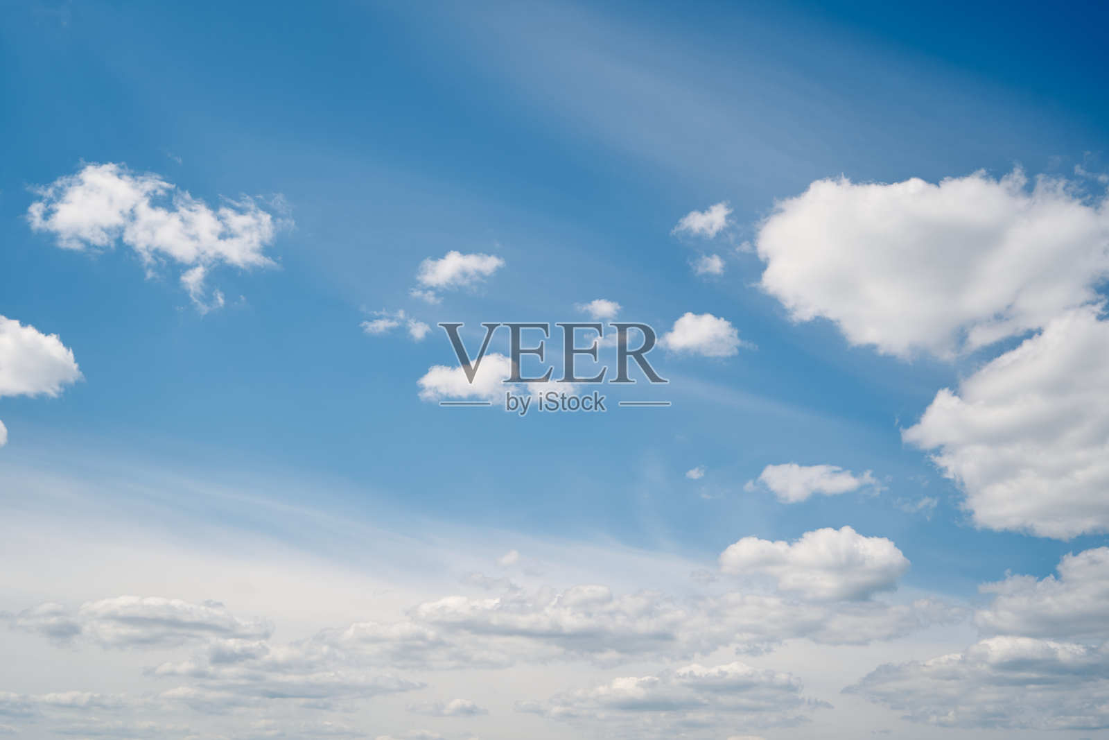 夏天的蓝天上飘着蓬松的白云。照片摄影图片