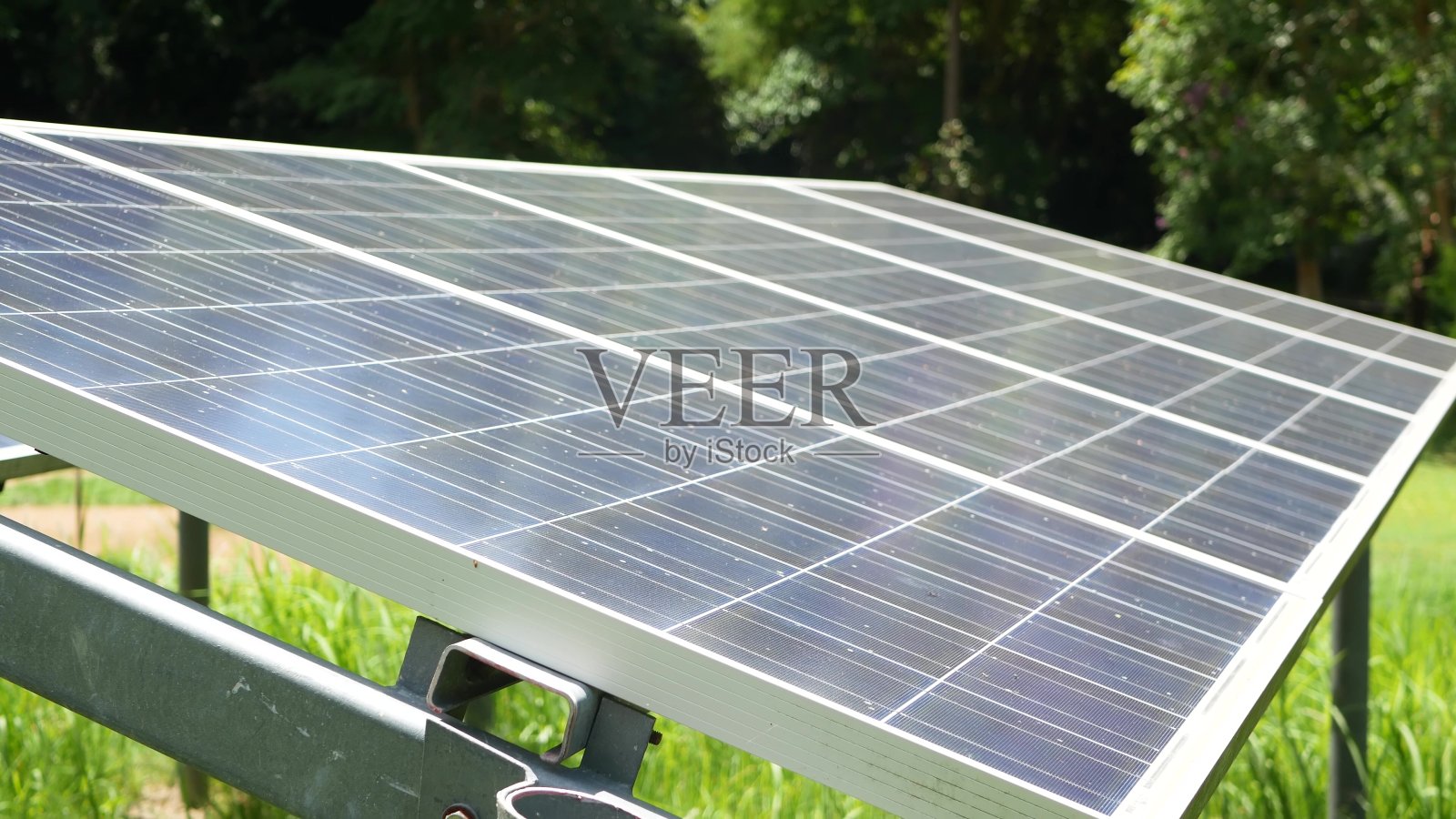 阳光明媚的日子，草地上的太阳能电池板。草坪上一排排可替代的发电厂生产生态能源。32、保护环境，走绿色理念。现代技术和创新。照片摄影图片