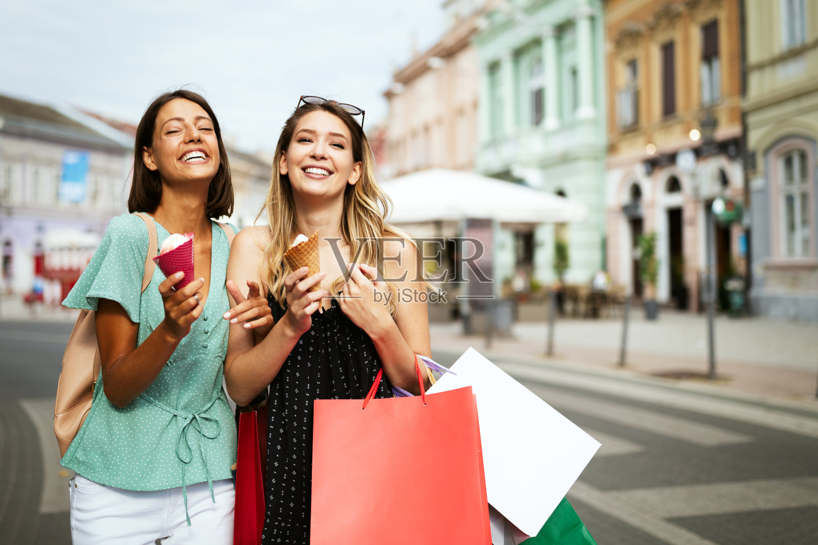 两个年轻的女性朋友在户外吃冰淇淋，玩得很开心照片摄影图片