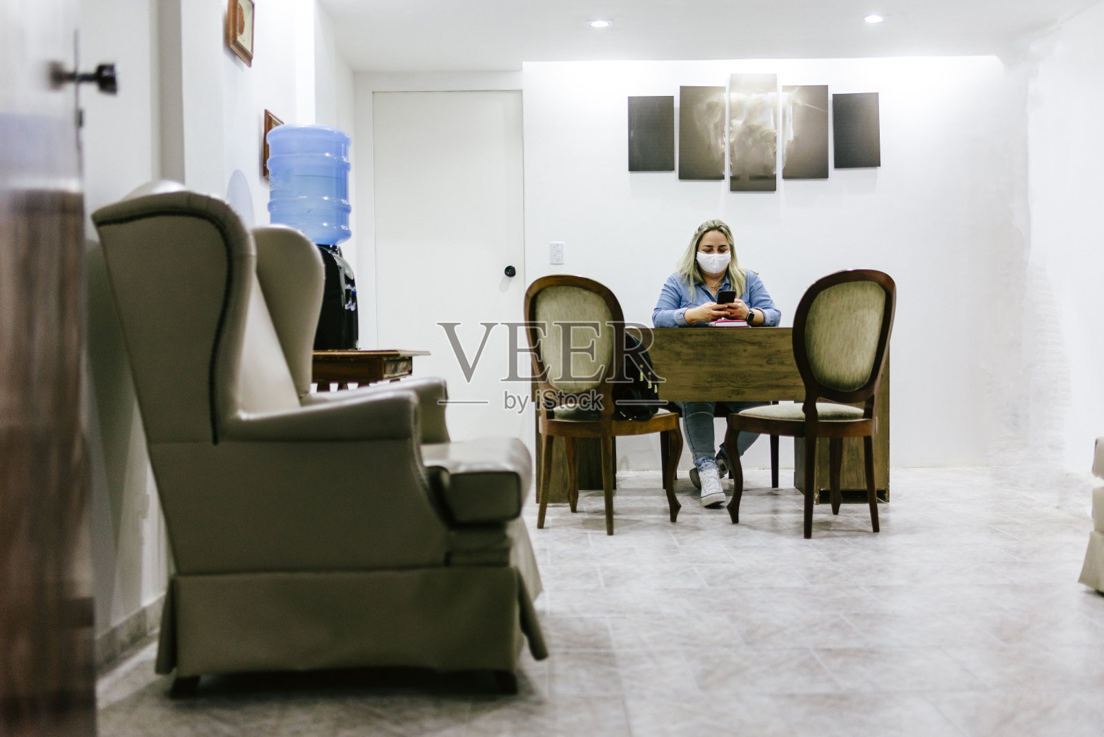 新常态:接待员在办公室里戴着防护口罩照片摄影图片