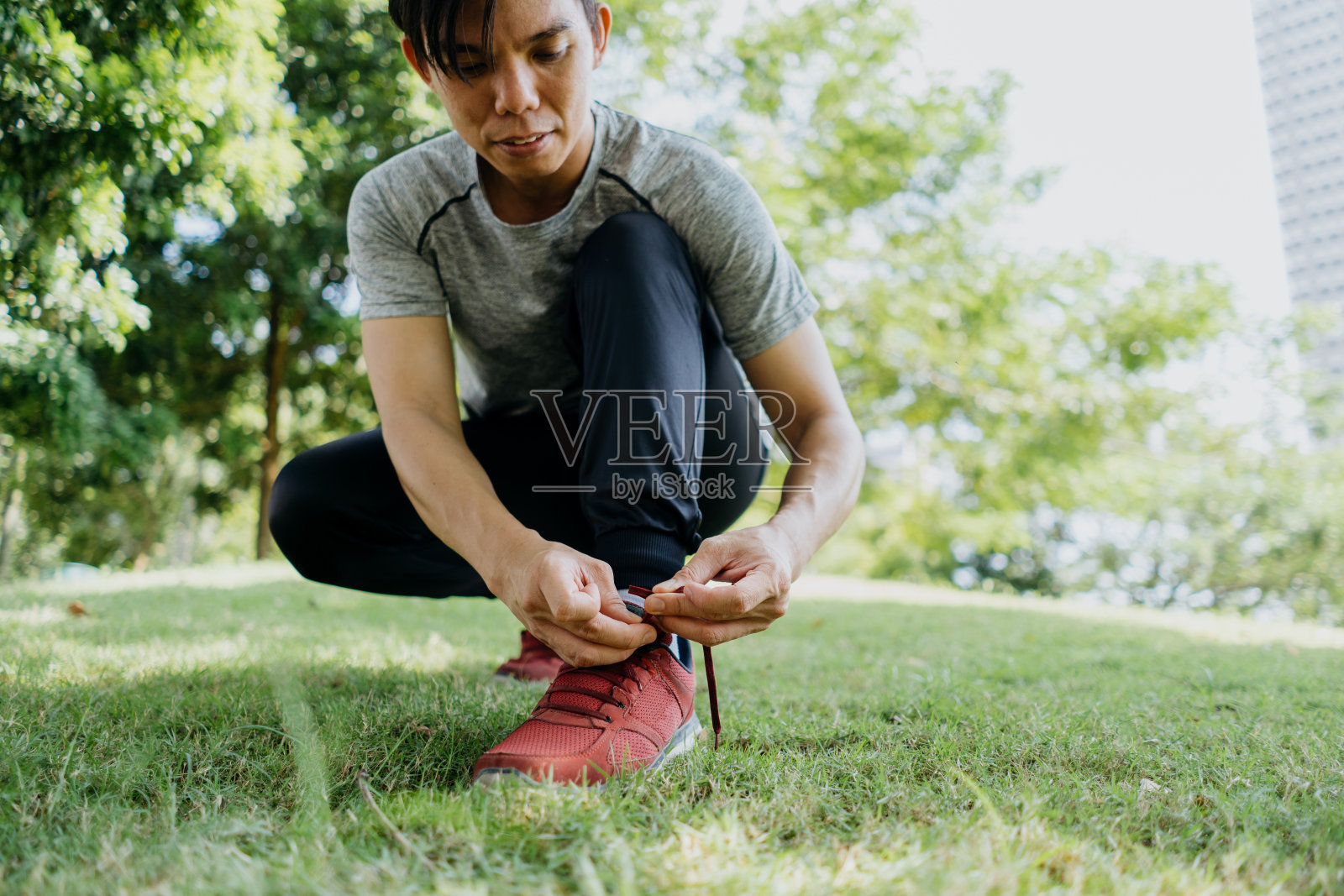年轻的亚洲男子系鞋带，准备跑步照片摄影图片