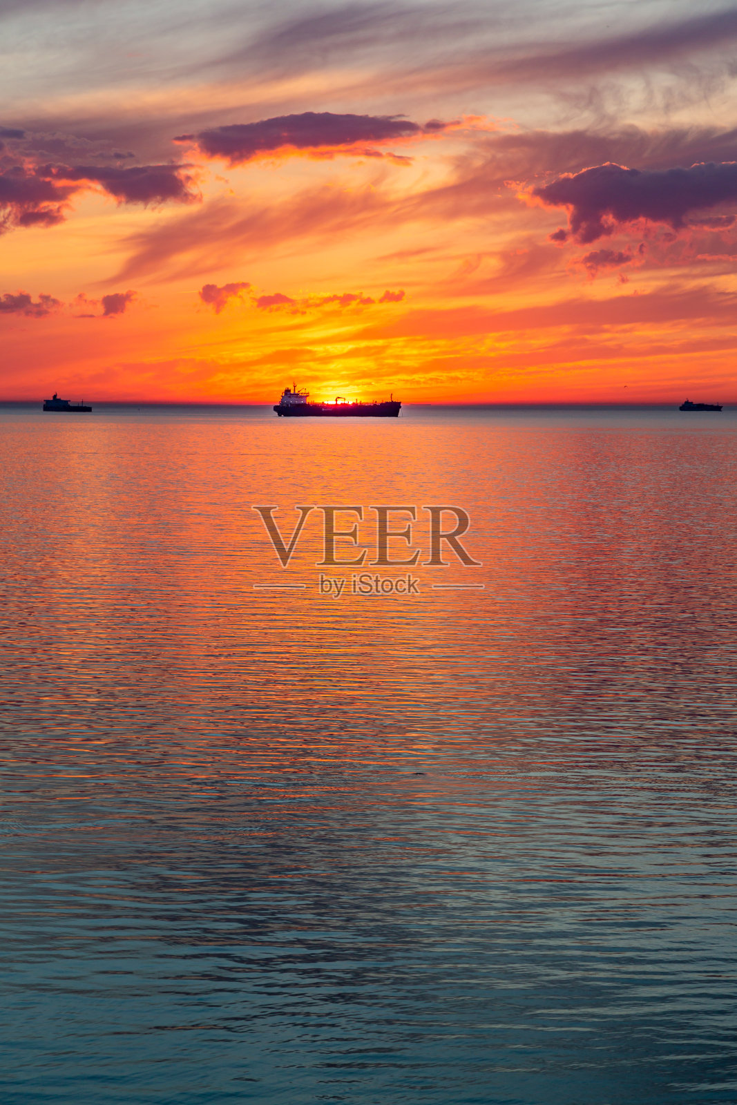 波罗的海与夕阳的天空和太阳透过云层之上。照片摄影图片