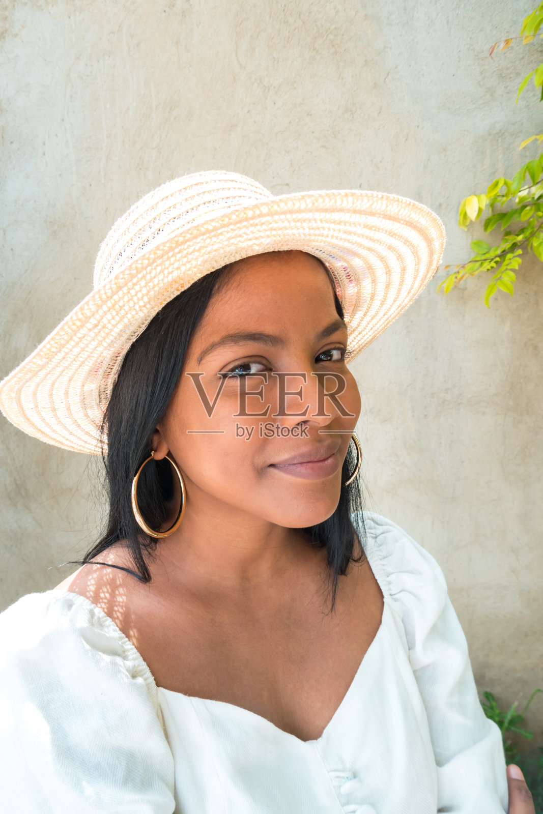 戴着帽子的年轻女子在公园里笑照片摄影图片