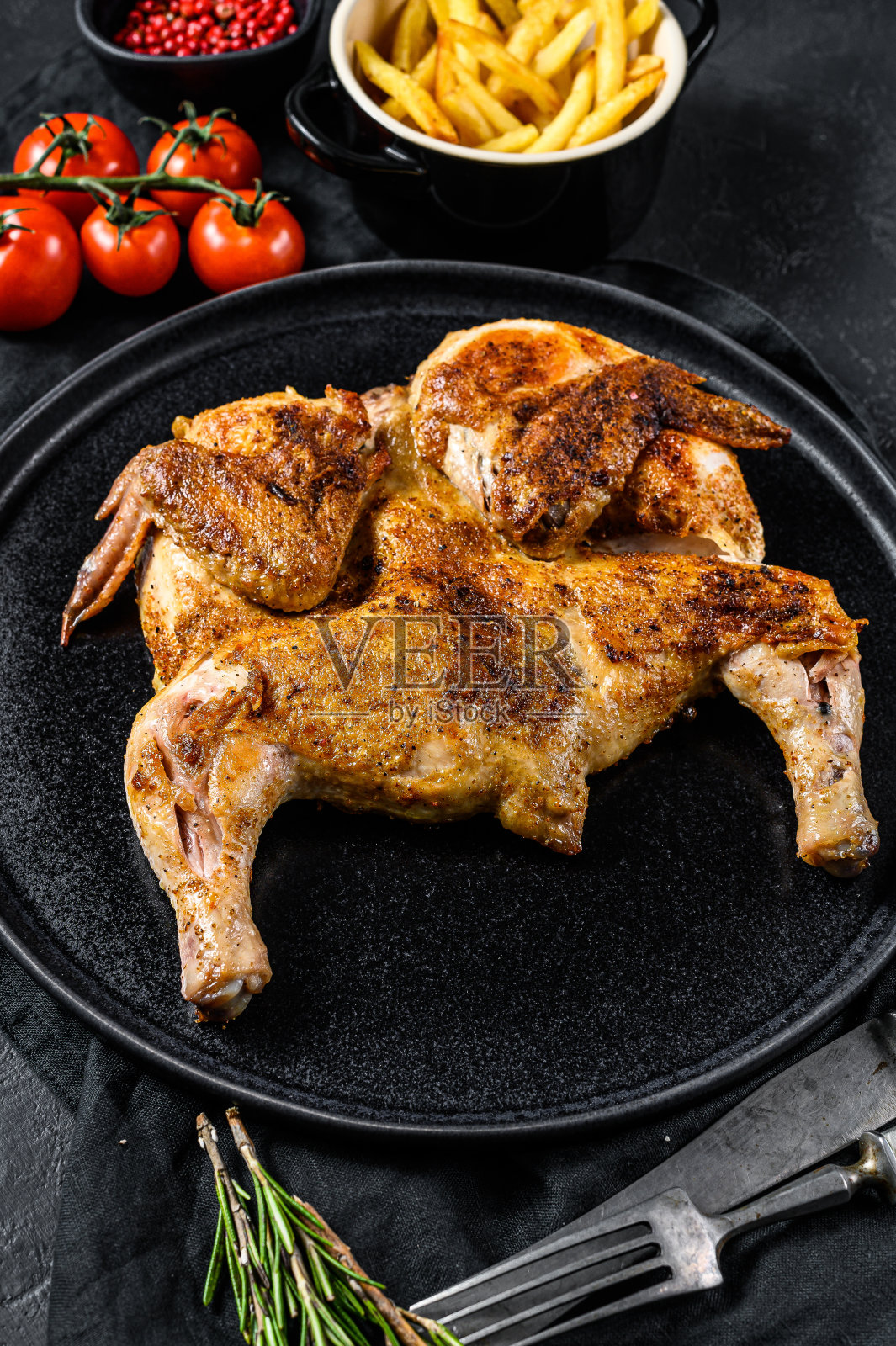 热炸鸡烟草与香草和大蒜。黑色背景。俯视图照片摄影图片