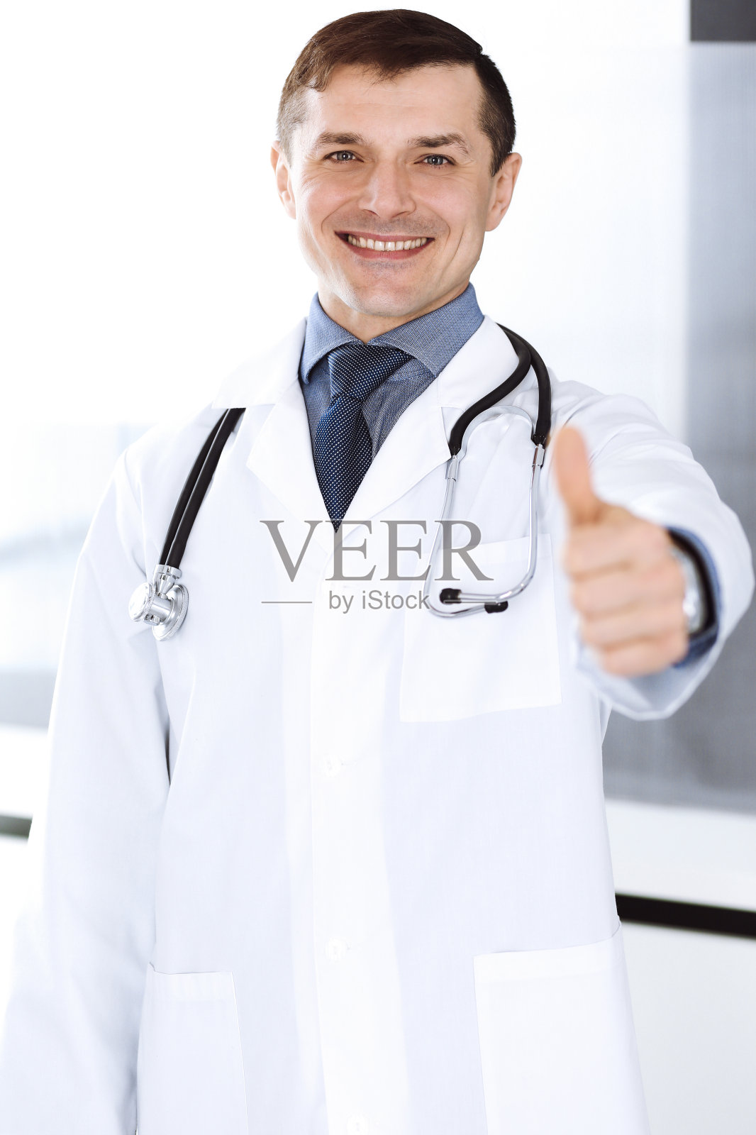 医生对着镜头微笑，竖起大拇指。诊所完善的医疗服务。医疗保健事业的美好未来照片摄影图片