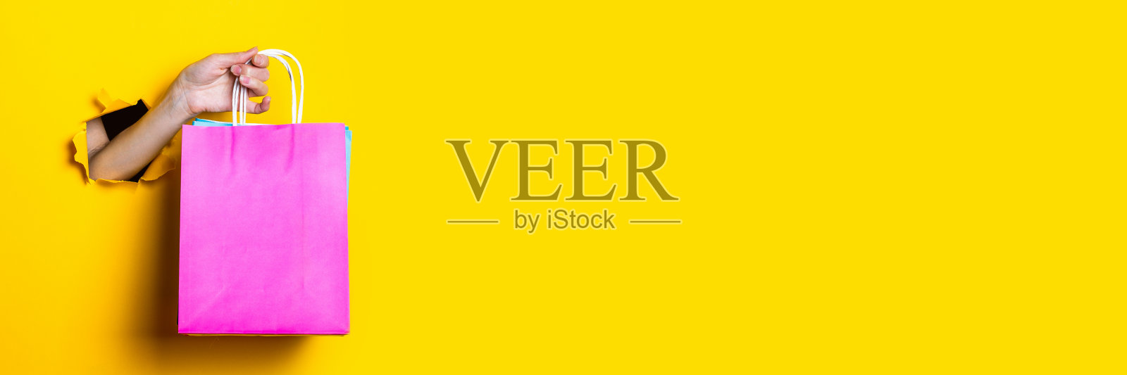 女人手里拿着黄色背景的包裹。横幅。照片摄影图片