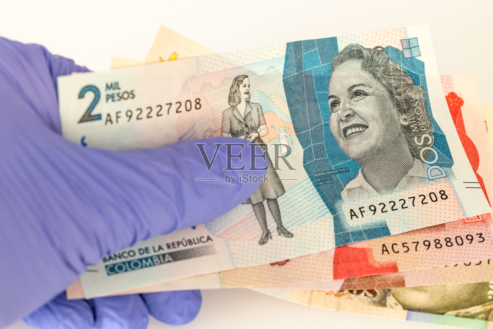 哥伦比亚的钱，放在橡胶手套里的比索。新冠肺炎大流行期间经济和金融威胁的概念照片摄影图片