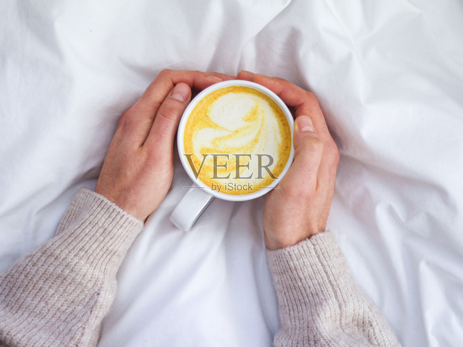 手里拿着姜黄拿铁照片摄影图片