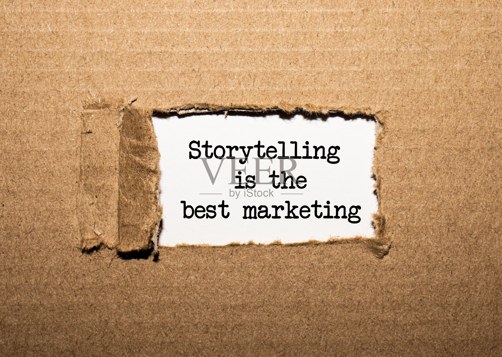 文字讲故事是最好的营销。在撕裂的牛皮纸后面照片摄影图片