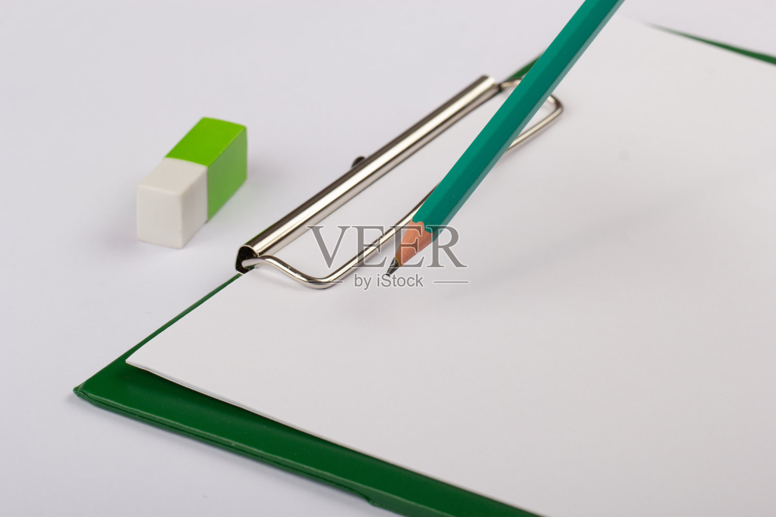 绿色空白笔记本与铅笔和橡皮隔离在白色照片摄影图片