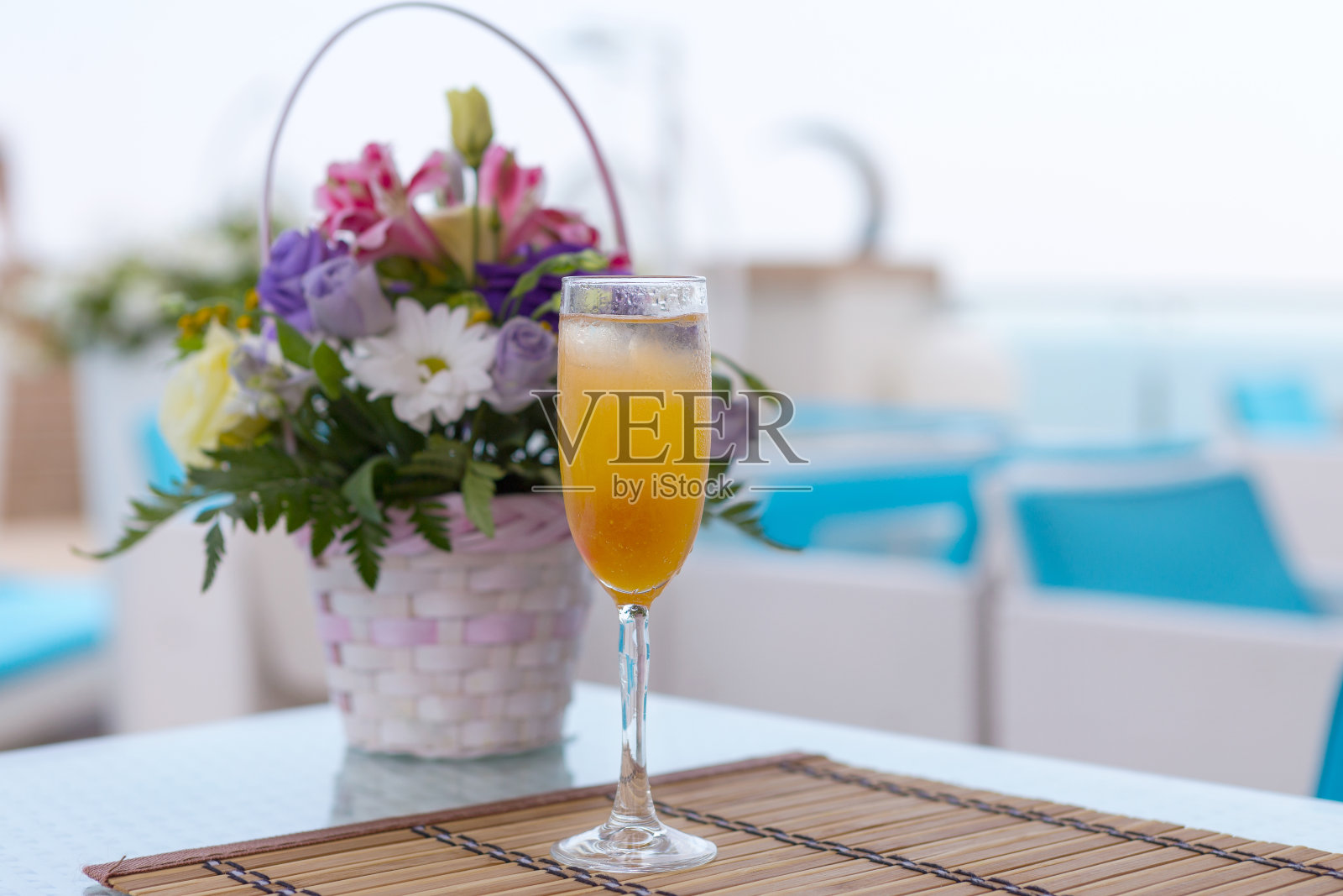 用玻璃杯盛有果汁的酒精饮料。模糊了美丽的花束。照片摄影图片