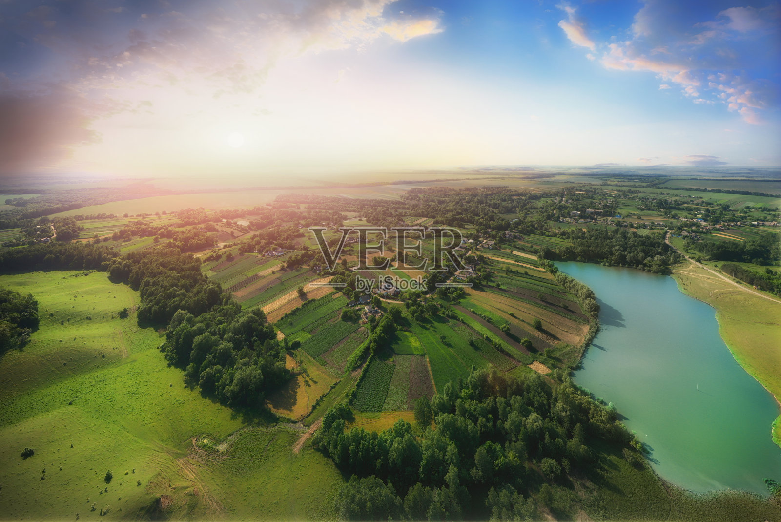 绿色田野上的日落鸟瞰图。照片摄影图片