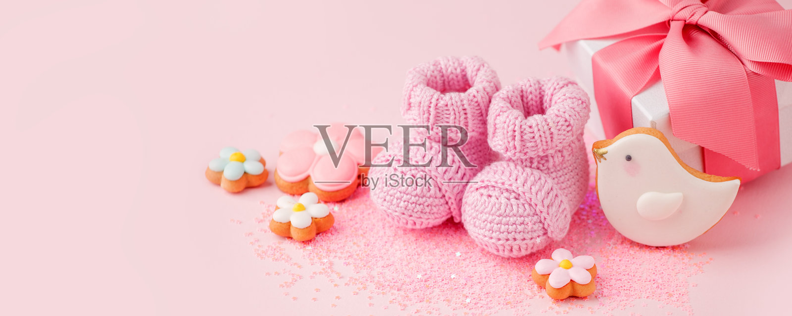 一双粉红色的小婴儿袜，饼干，粉红色背景的礼物盒，为您的温馨信息拷贝空间，宝宝送礼会，第一个新生儿派对背景，拷贝空间，单色，横幅照片摄影图片