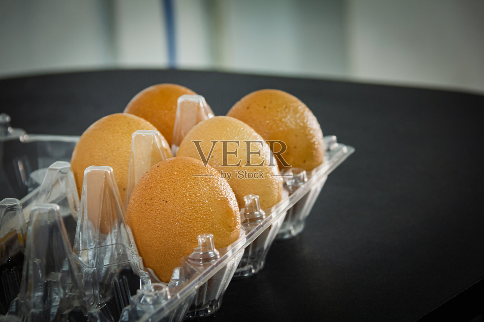 将蛋滴入水，放在黑色的桌子上防止损坏照片摄影图片