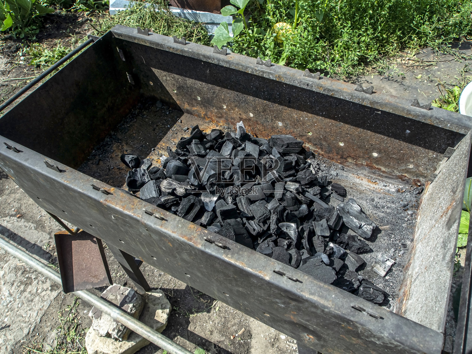 煮羊肉串用的现成木炭倒在金属烤架上照片摄影图片