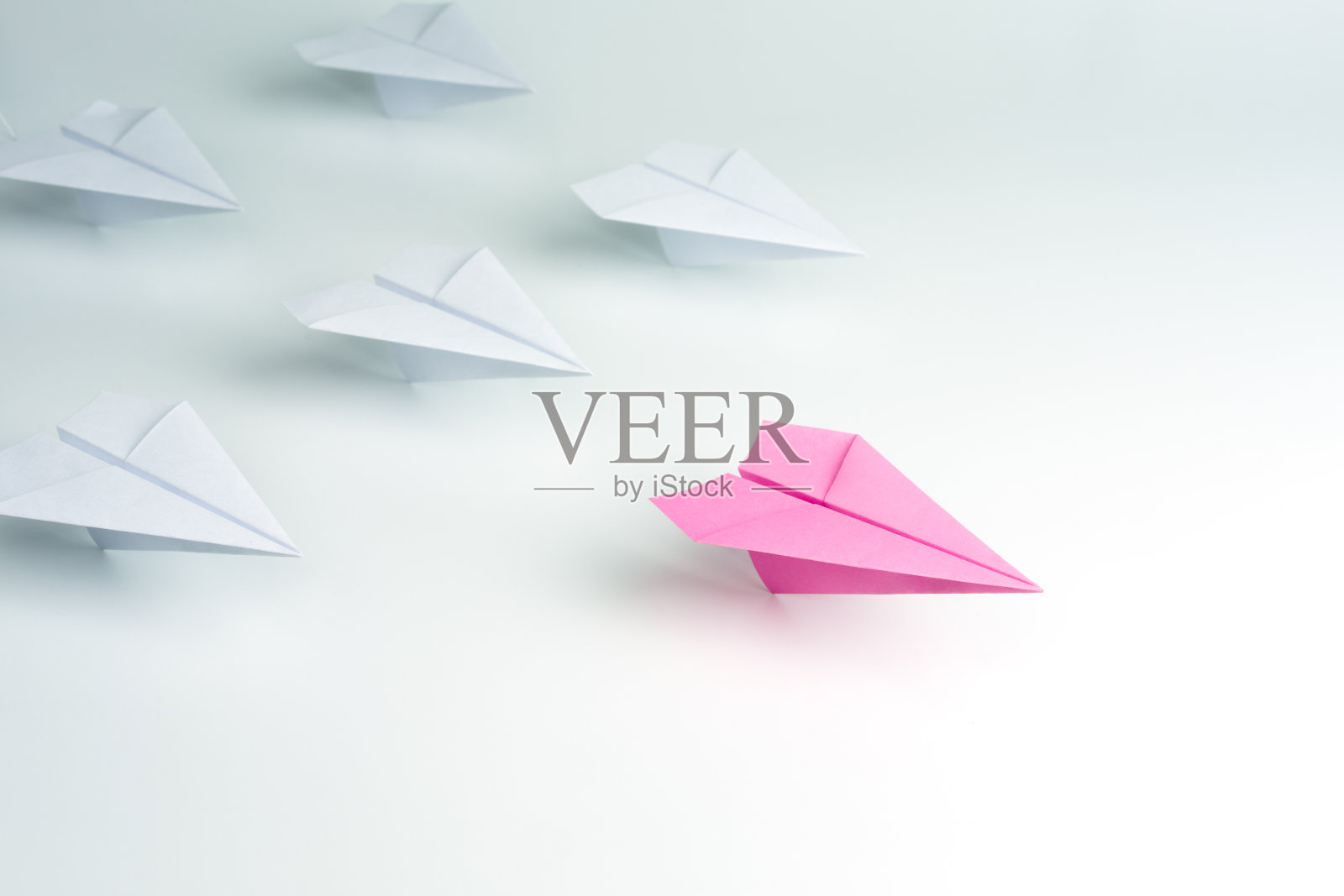 女性领导理念以粉色纸飞机在白色中领先。照片摄影图片