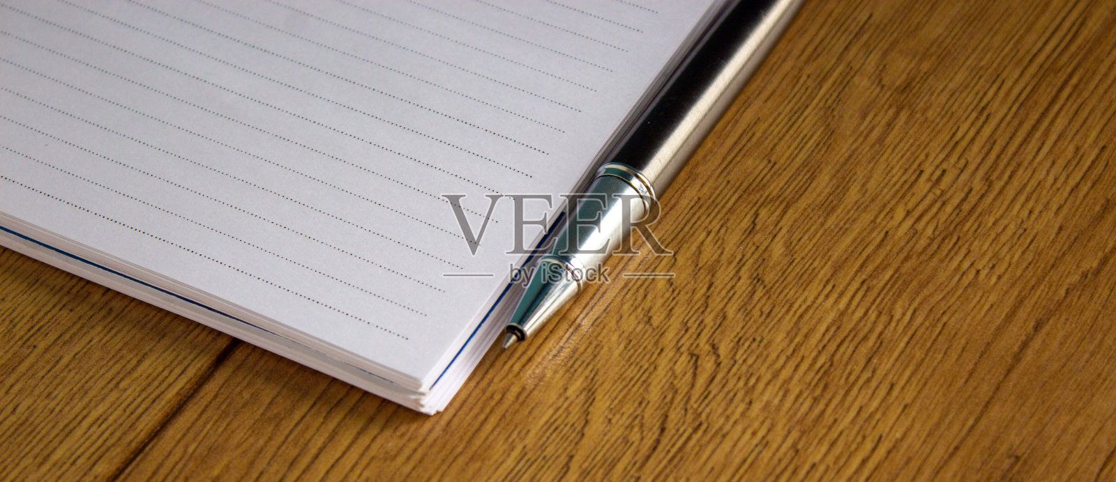 笔记本和钢笔放在木桌上。商业教育理念。照片摄影图片