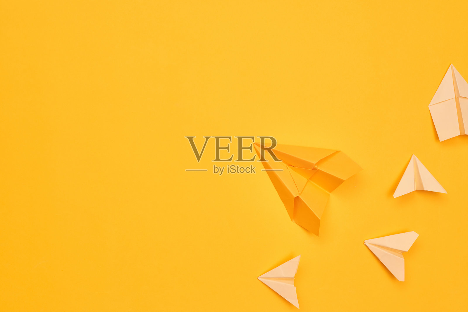 极简主义的黄色纸飞机在黄色的背景。旅行，飞行，平面层，复制空间一照片摄影图片