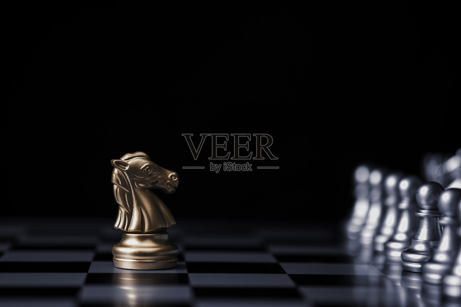 金马棋在棋盘和黑色背景上遭遇银棋敌人。市场或商业竞争对手的概念。照片摄影图片