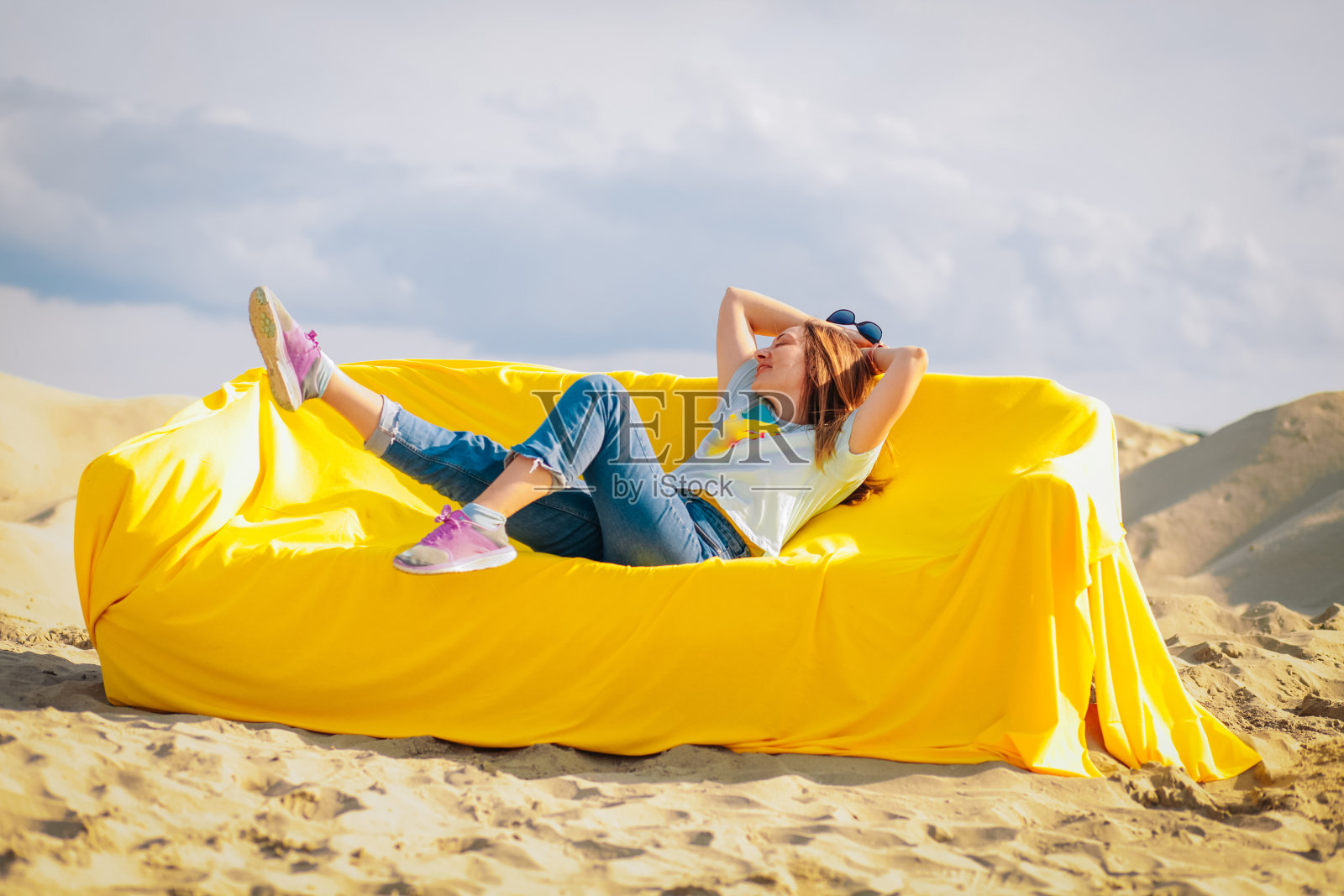 坐在沙漠中间黄色沙发上的女人照片摄影图片
