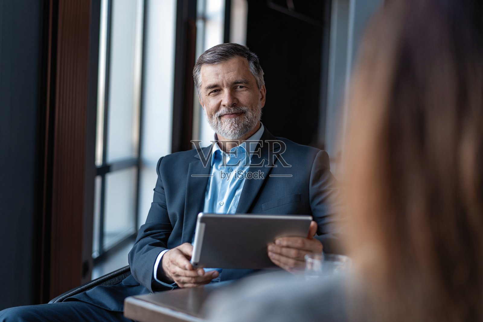 成熟商人采访女性的形象。照片摄影图片