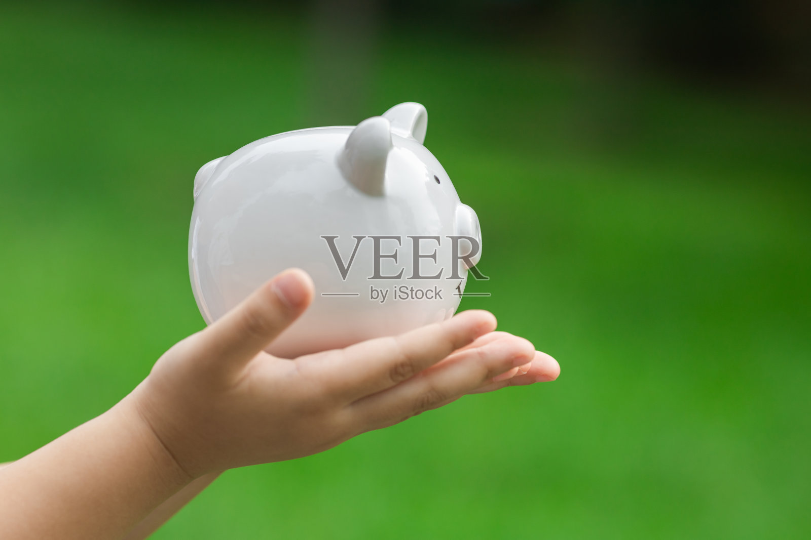 抱着存钱罐的孩子照片摄影图片