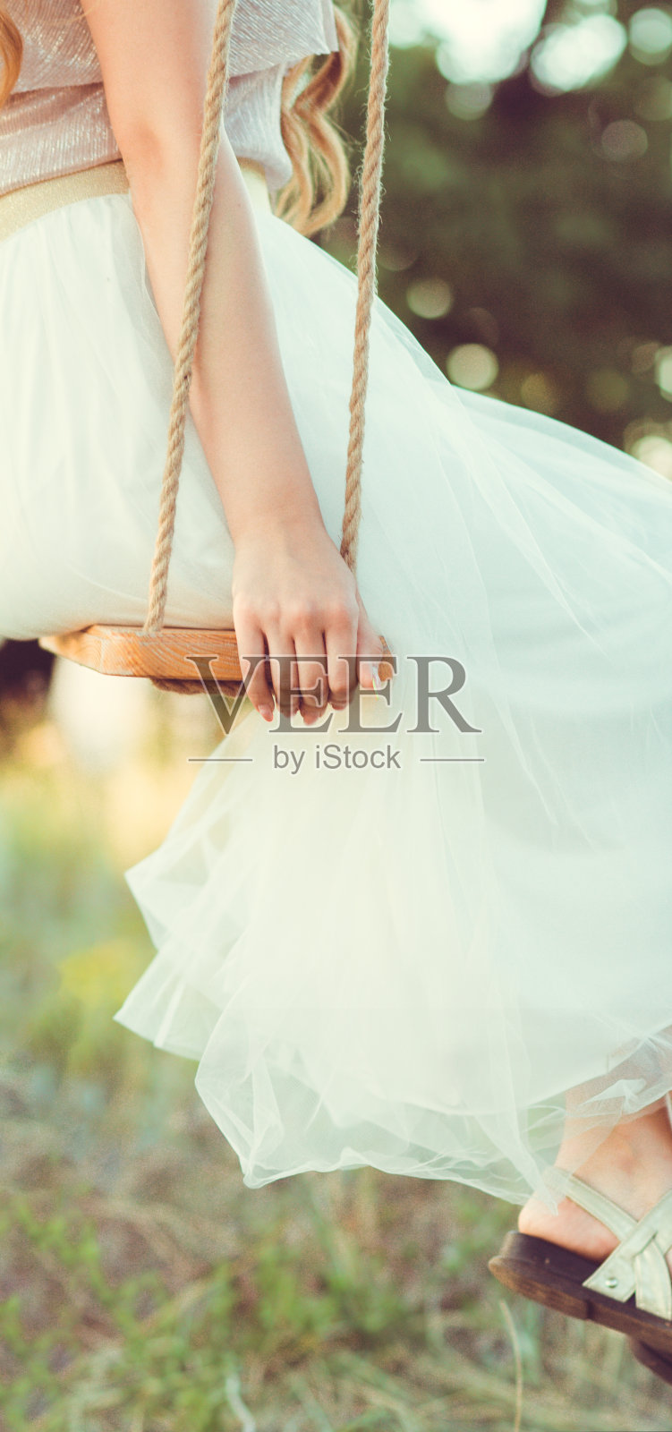 女孩坐在木制秋千上乘凉自然，年轻女子放松，休闲活动，生活理念照片摄影图片