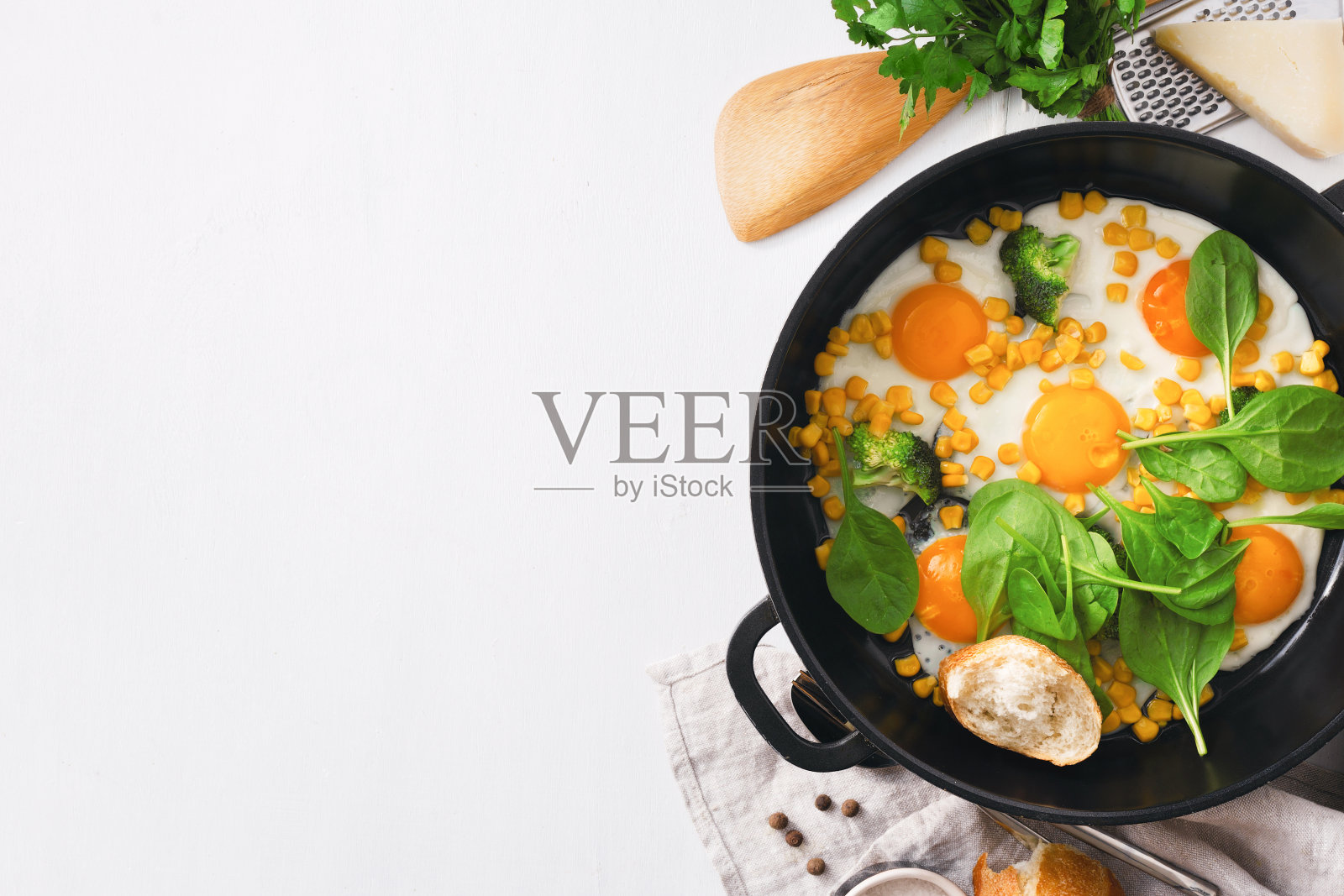 健康早餐桌子与煎锅鸡蛋与菠菜在白色背景拷贝空间俯视图照片摄影图片