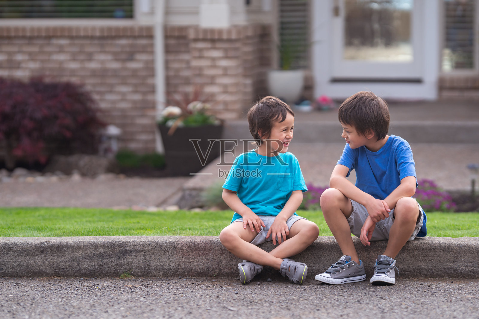 两兄弟一起坐在路边的画像照片摄影图片