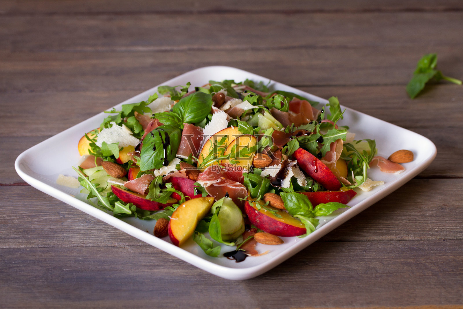 蜜桃火腿沙拉配芝士，罗勒，芝麻菜和黄瓜照片摄影图片