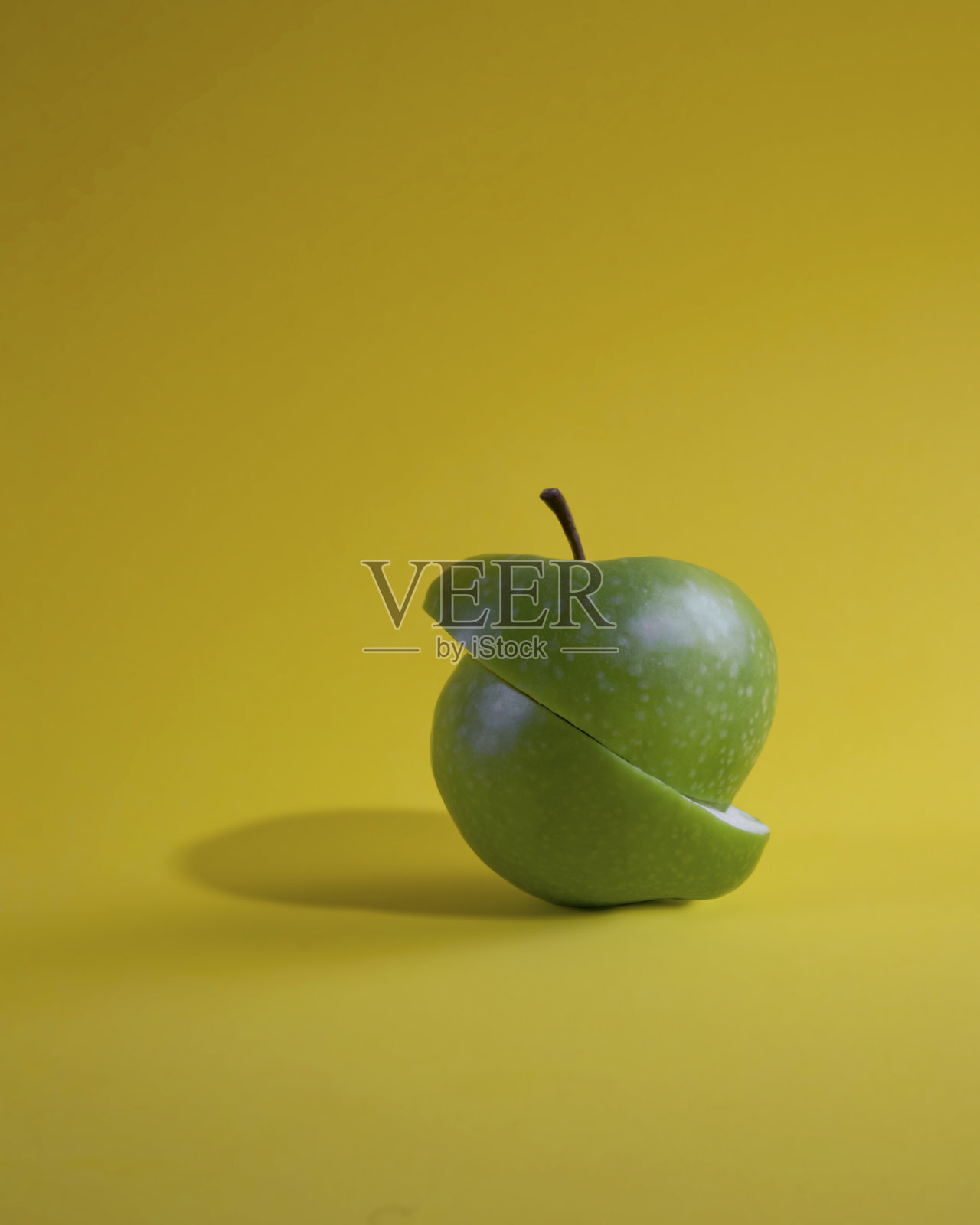 切青苹果，孤立在黄色背景上照片摄影图片