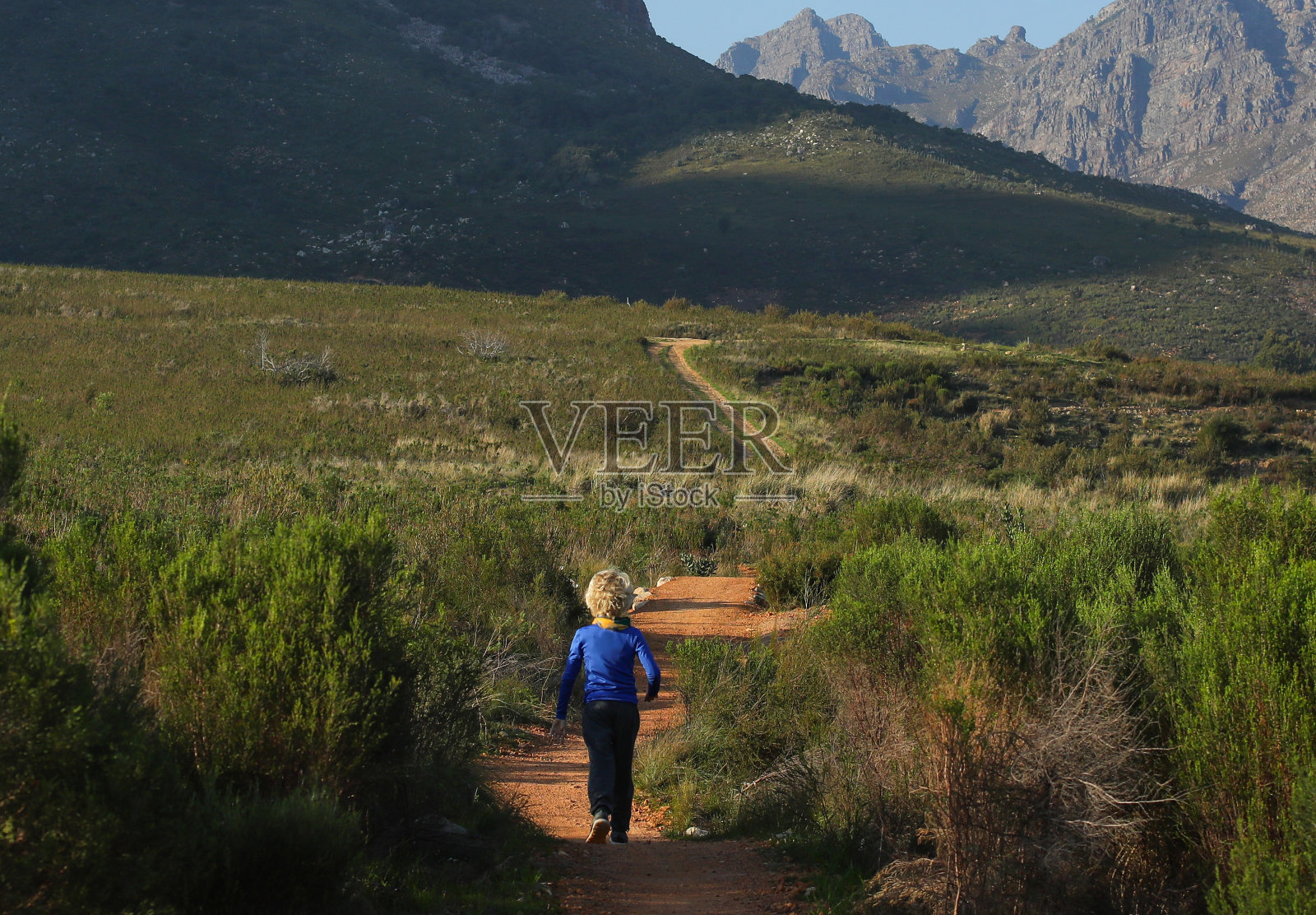 一个小男孩在山里的单行道上跑步照片摄影图片