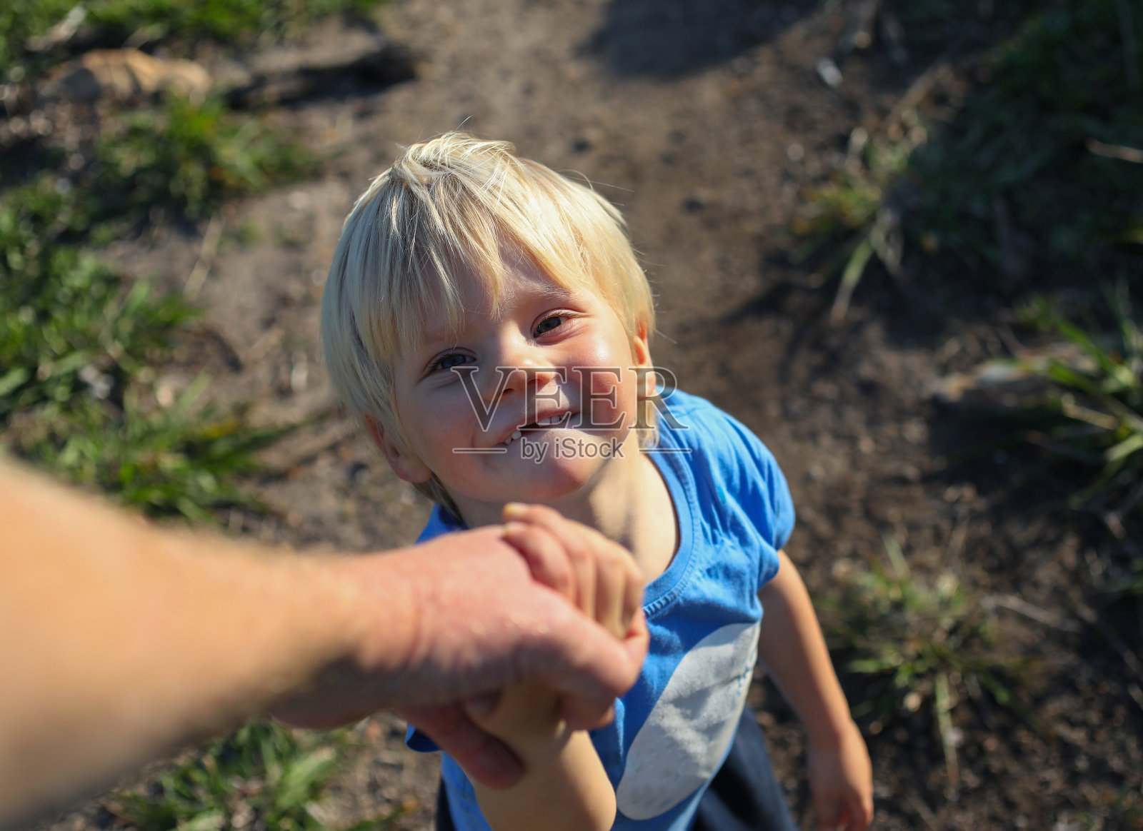 一个小男孩在爬山时牵着他父亲的手照片摄影图片