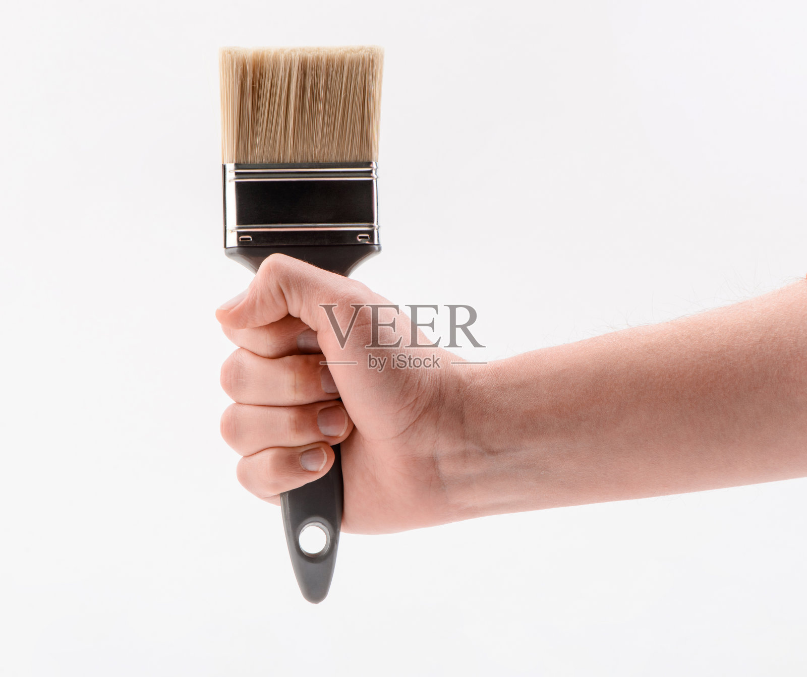 手紧紧地握着画笔，孤立在白色的背景上照片摄影图片