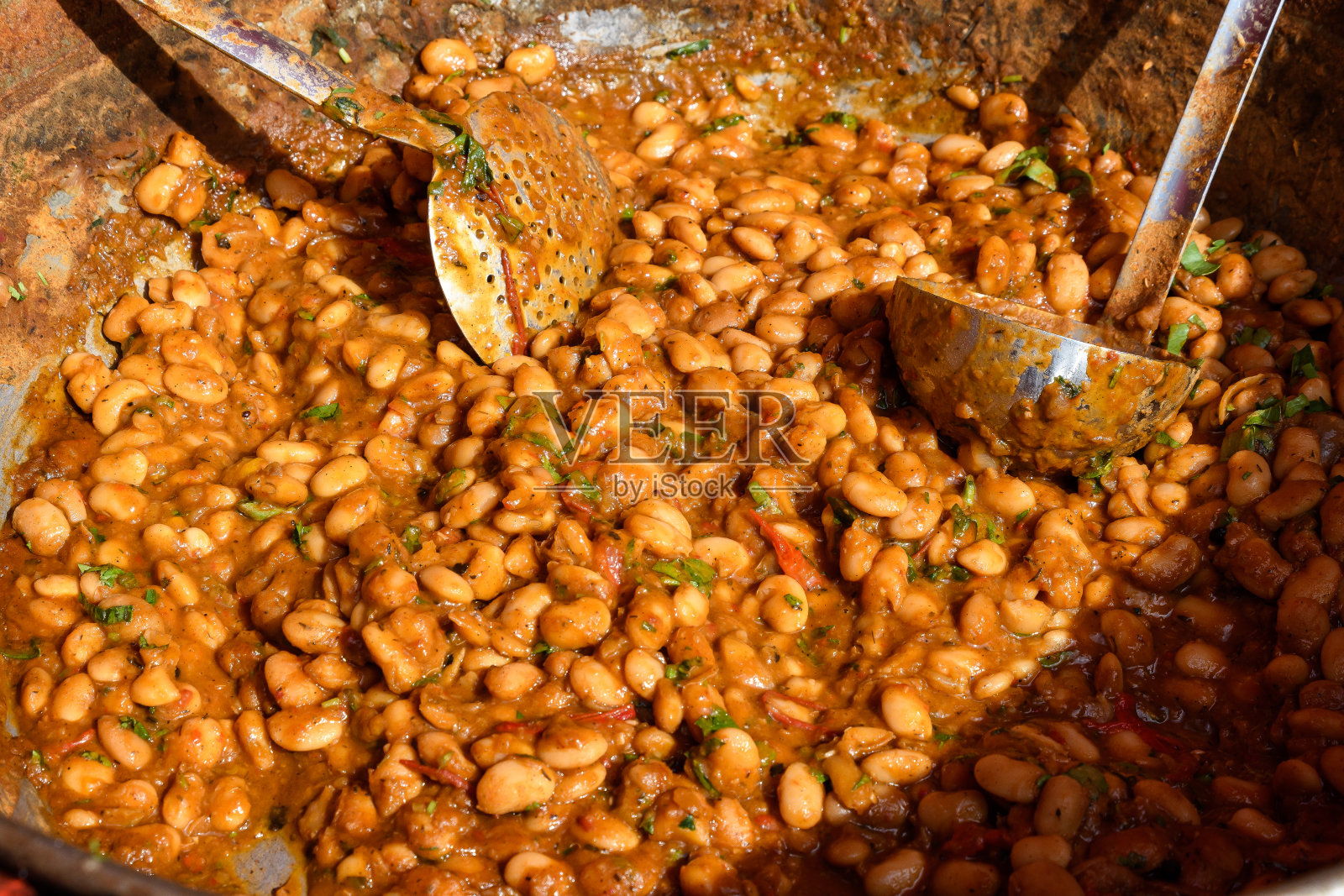 这是一个街头小吃市场上的特写镜头，一大块用番茄酱和辣椒新鲜烹制的白豆，用柔和的镜头拍摄健康的素食食品照片摄影图片