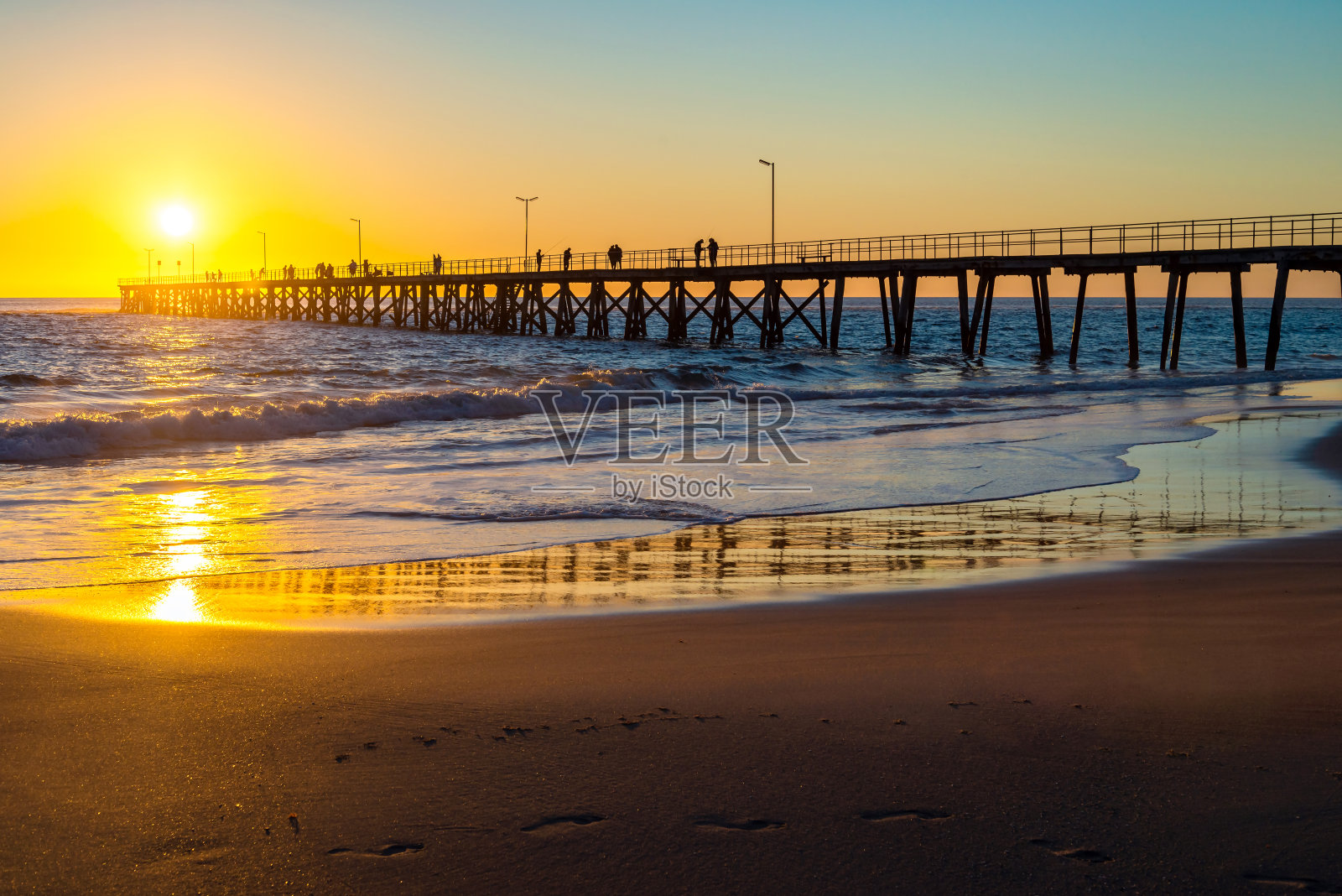 日落时分，渔民在诺伦加港码头上照片摄影图片