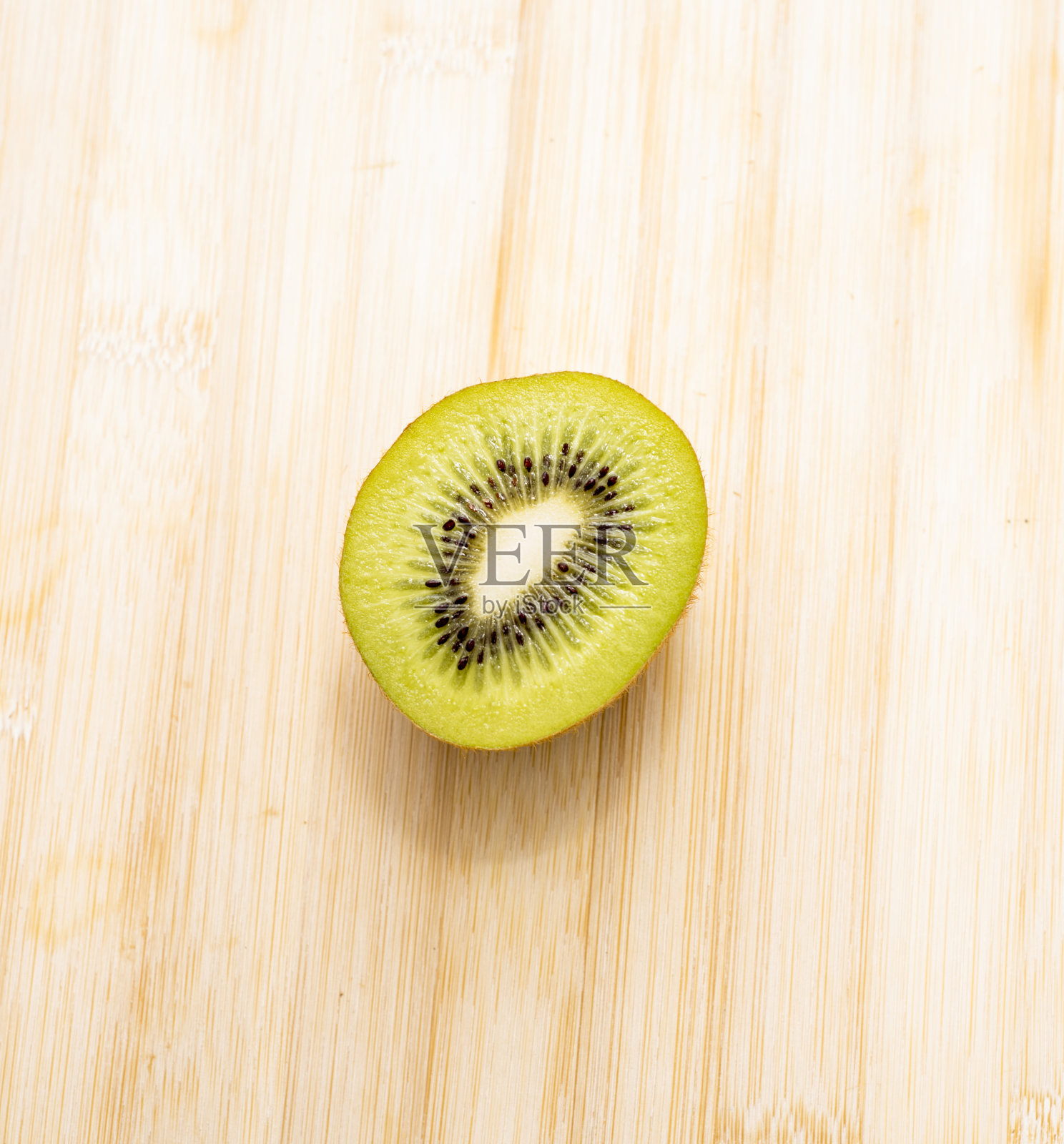 新鲜多汁的猕猴桃切在白色背景，竹和石板照片摄影图片