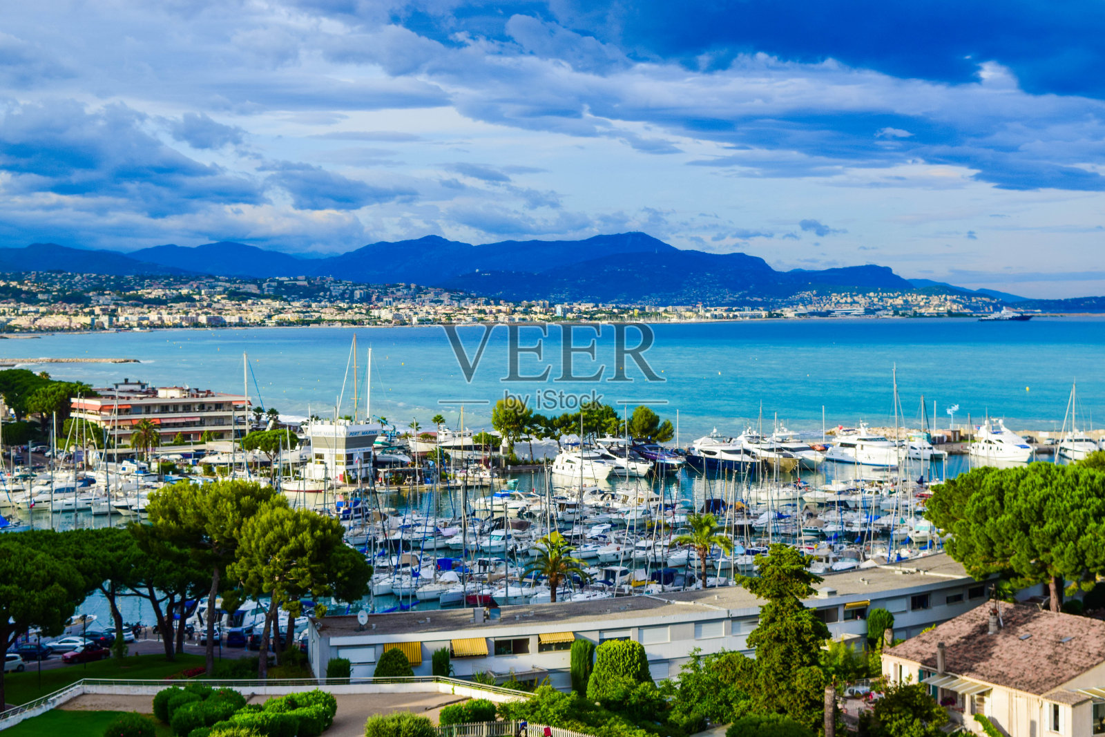 游艇、帆船和尼斯城的背景映衬着地中海的海滨风光。照片摄影图片